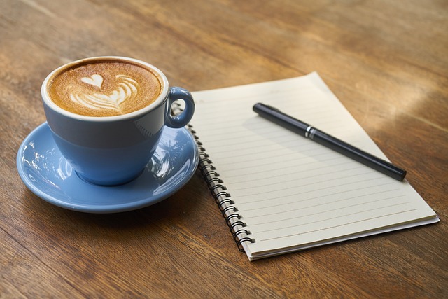 coffee cup next to a notebook with positive good morning messages