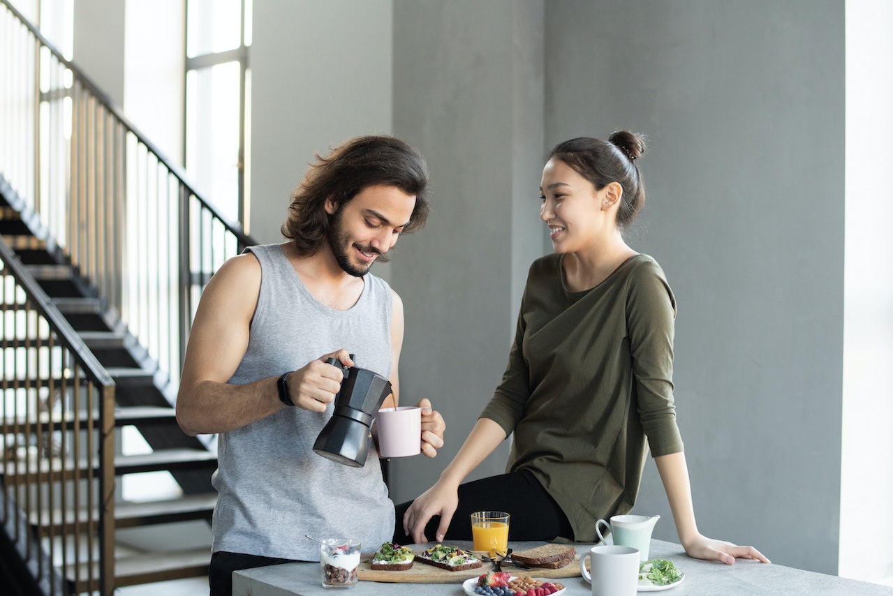 couple having coffee in the morning while wife says good morning for him