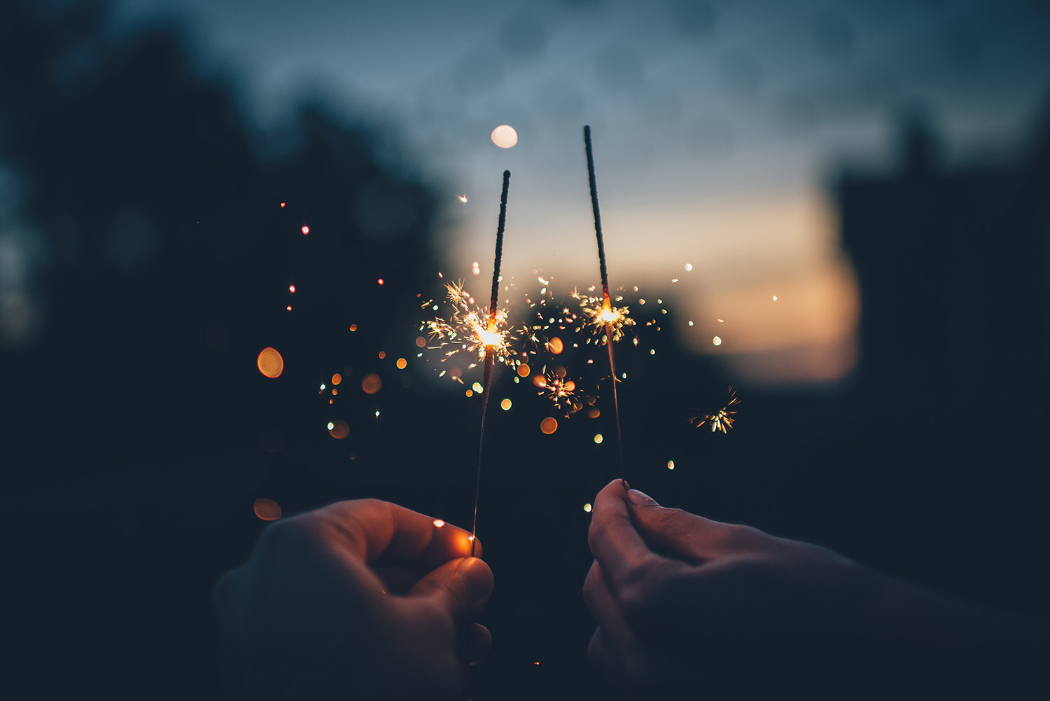 two hands holding candles in new year