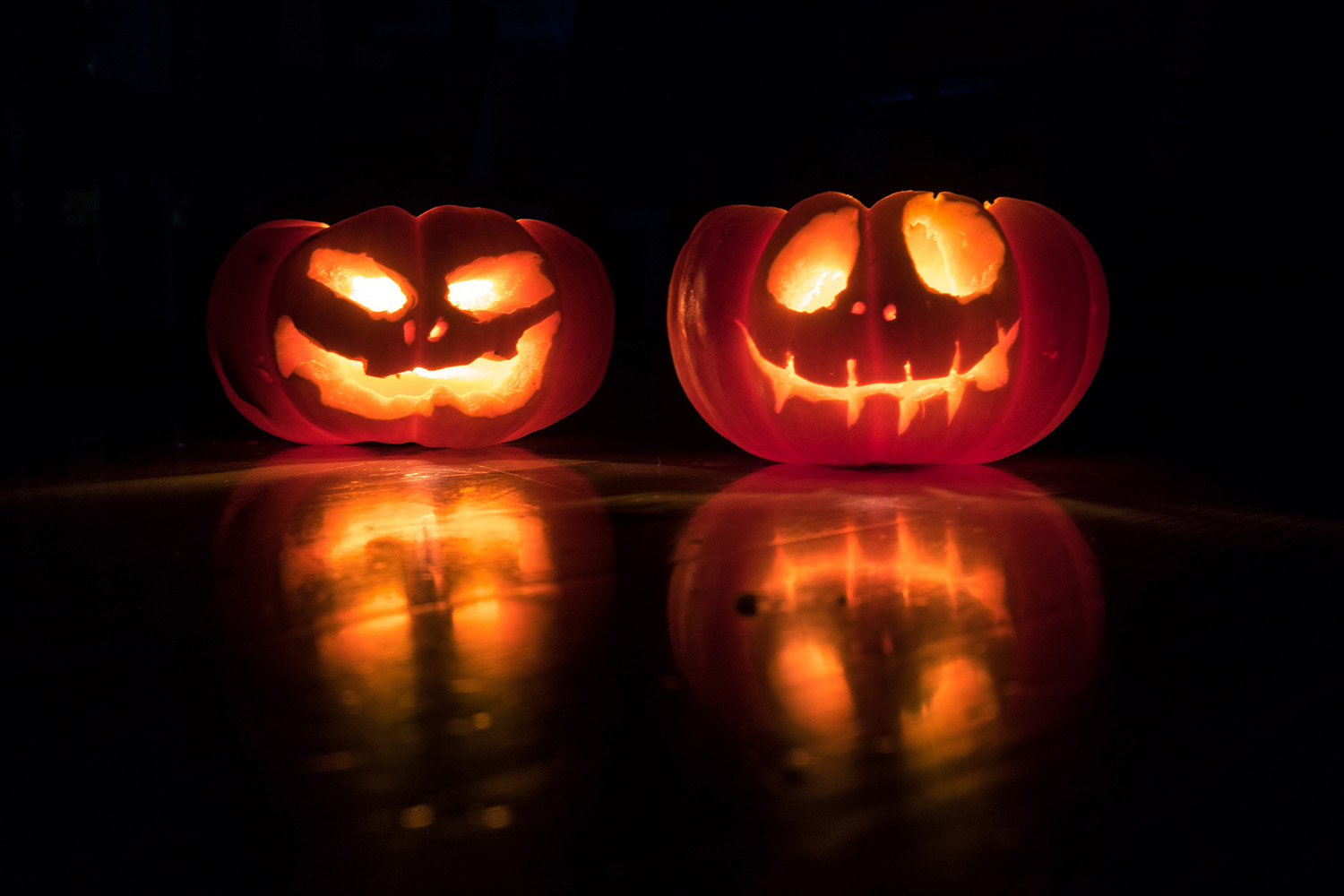 two halloween pumpkins in the dark