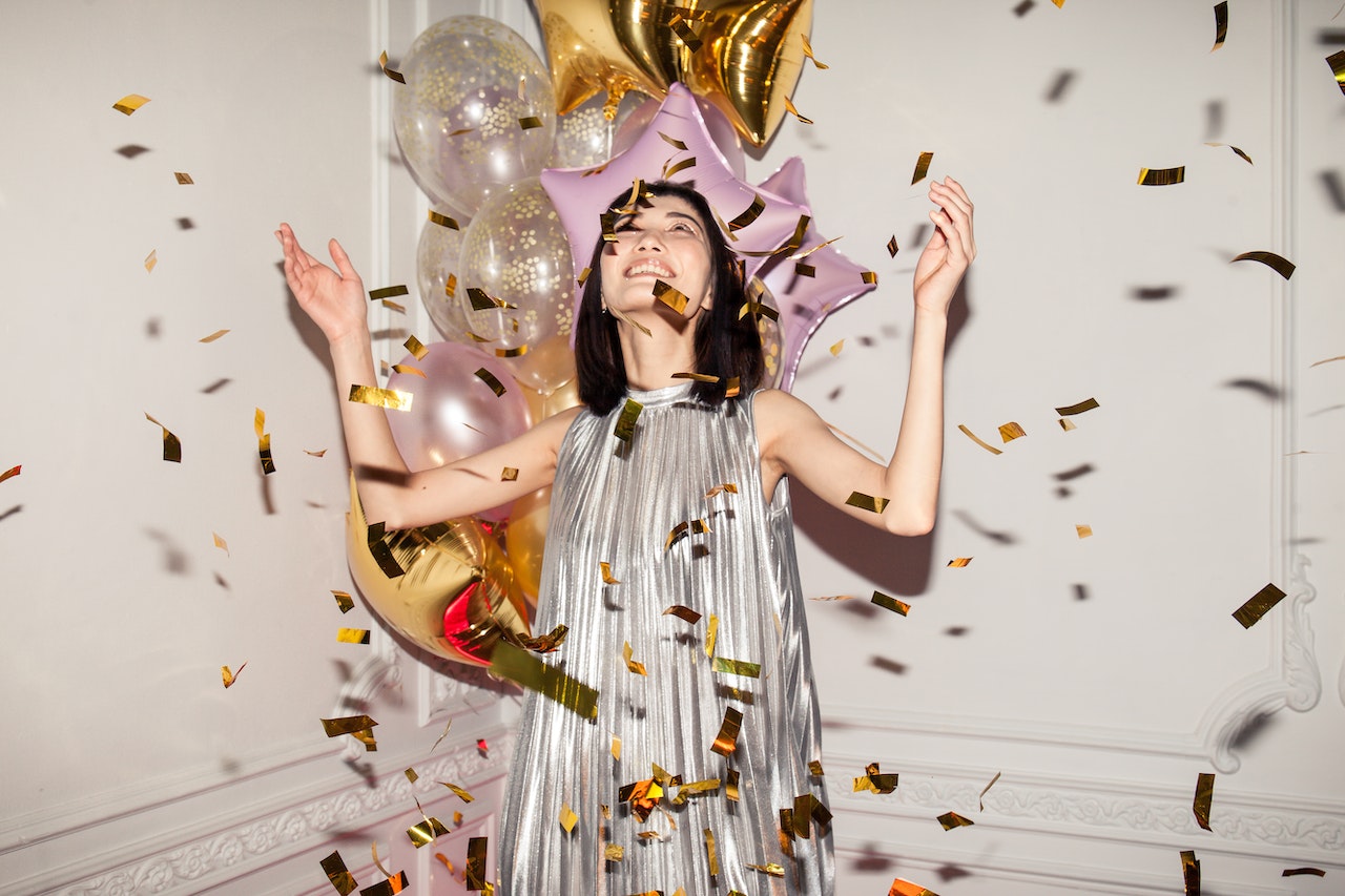 woman celebrating her birthday with confetti and receiving happy birthday messages