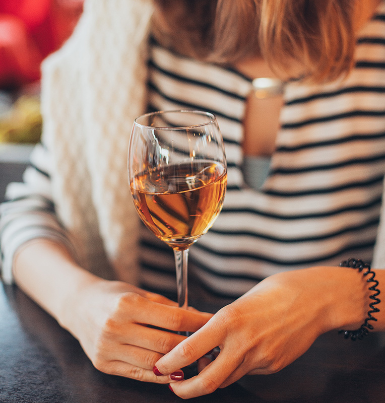 woman holding a glass of wine from a wine subscription