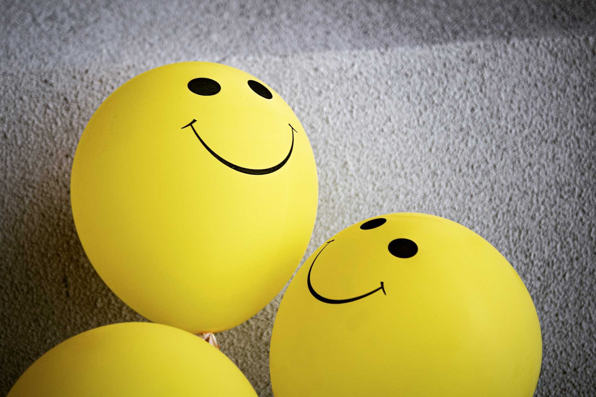 yellow balloons with smiles showing compliments and positivity