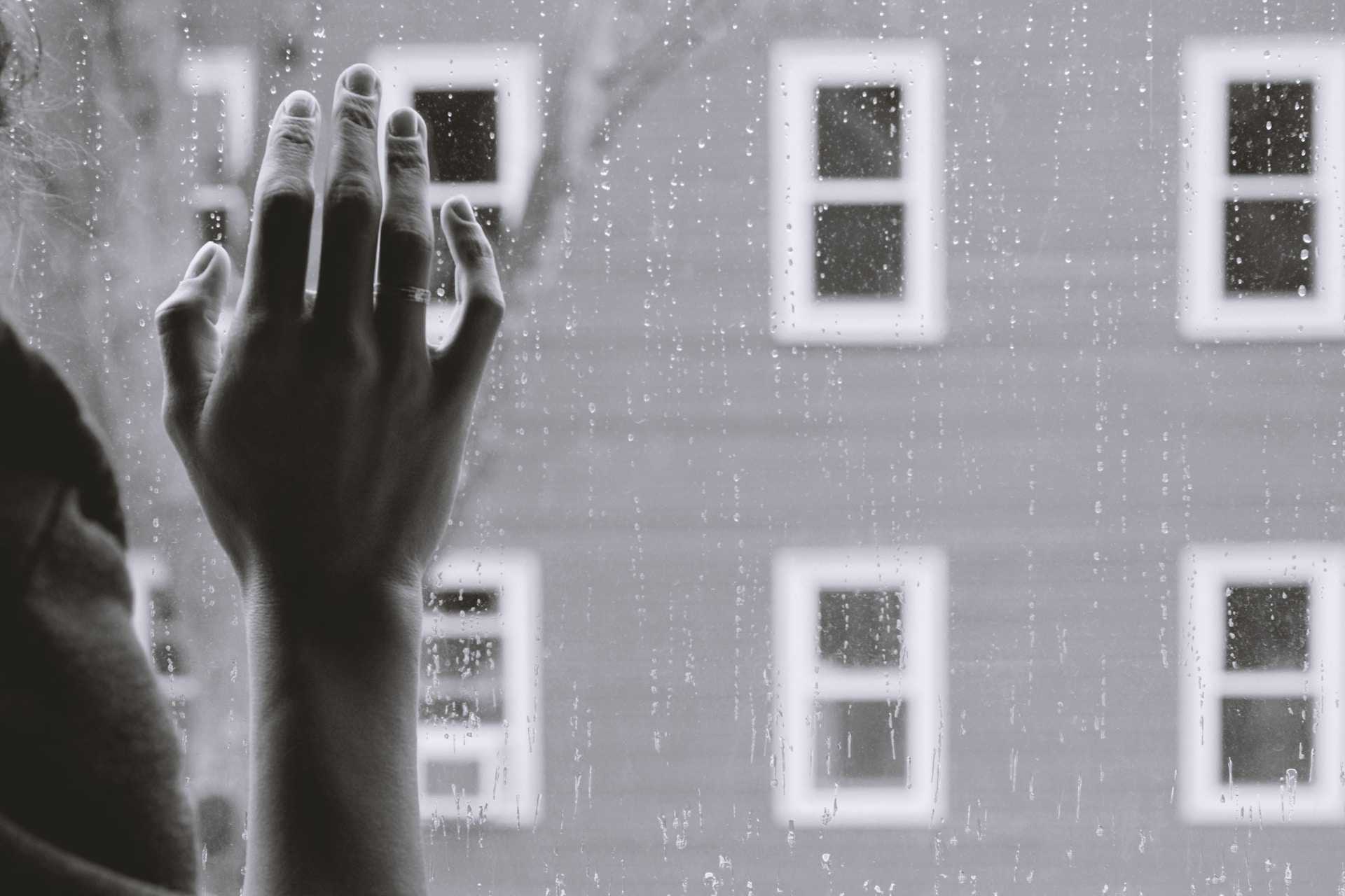 hand touching a glass window in a rainy day saying i miss you love messages