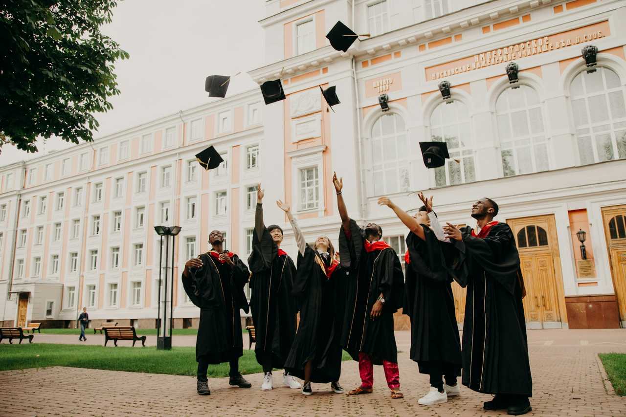 Graduating students throwing the graduation hats up celebrating their graduation 
