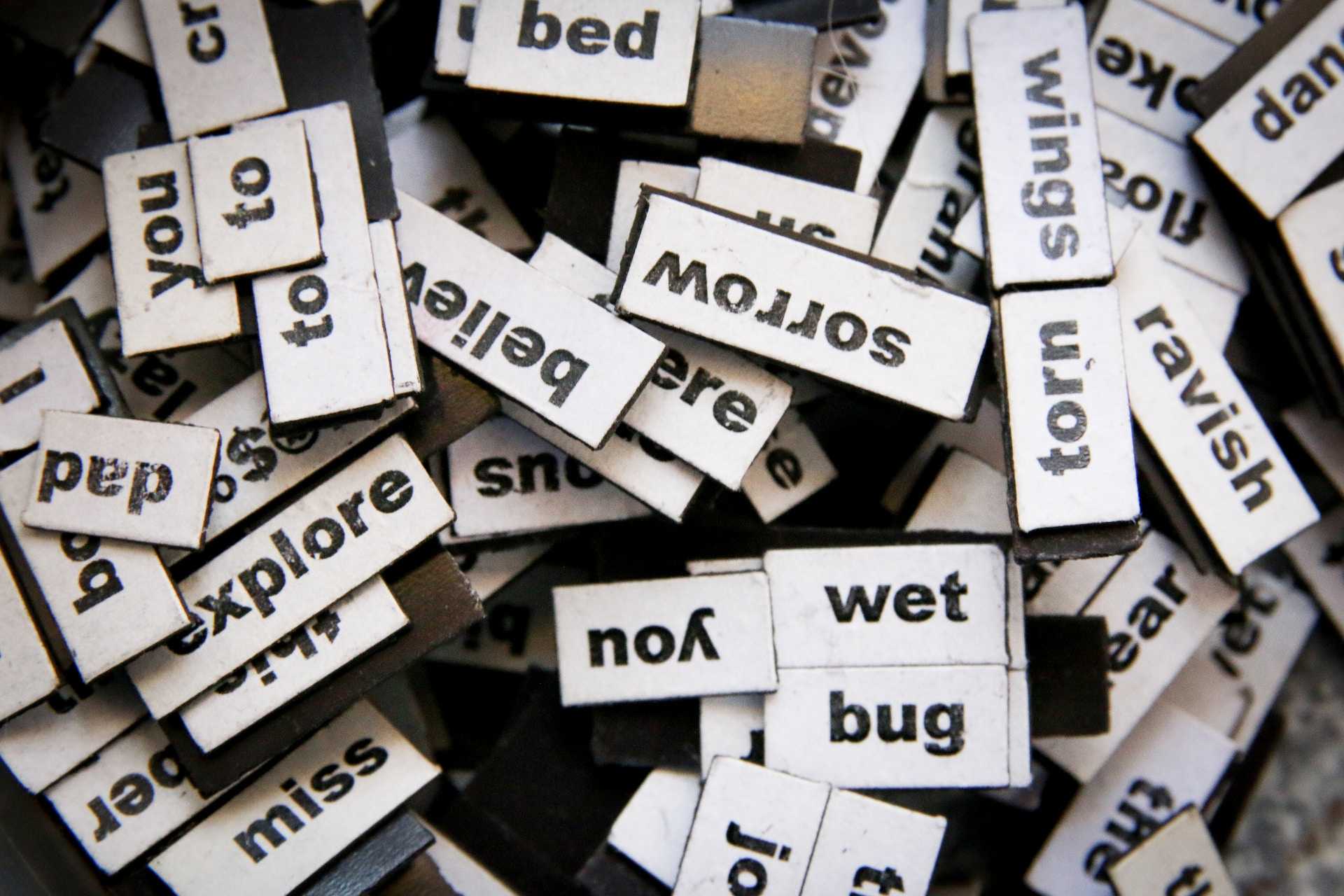 pile of word tiles where is hard to find words to write a compliment