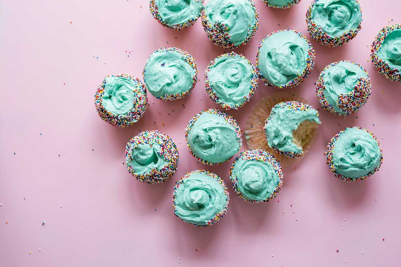 cupcakes with blue cream for a brother's birthday over a pink background
