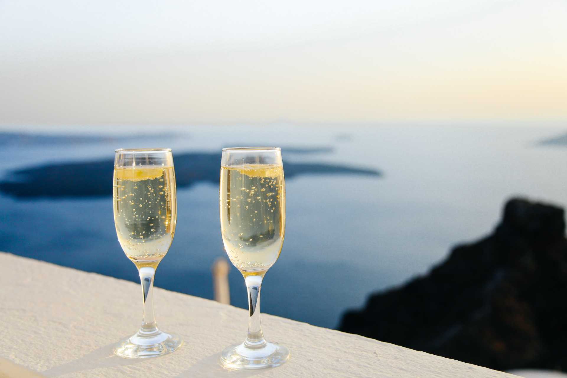 two glasses champagne with a view to the coast from a couple saying ai happy anniversary messages