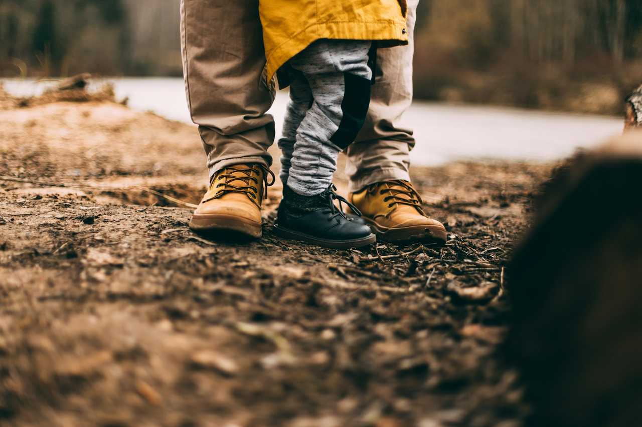 detail of father and daughter shoes during a hike in autumn