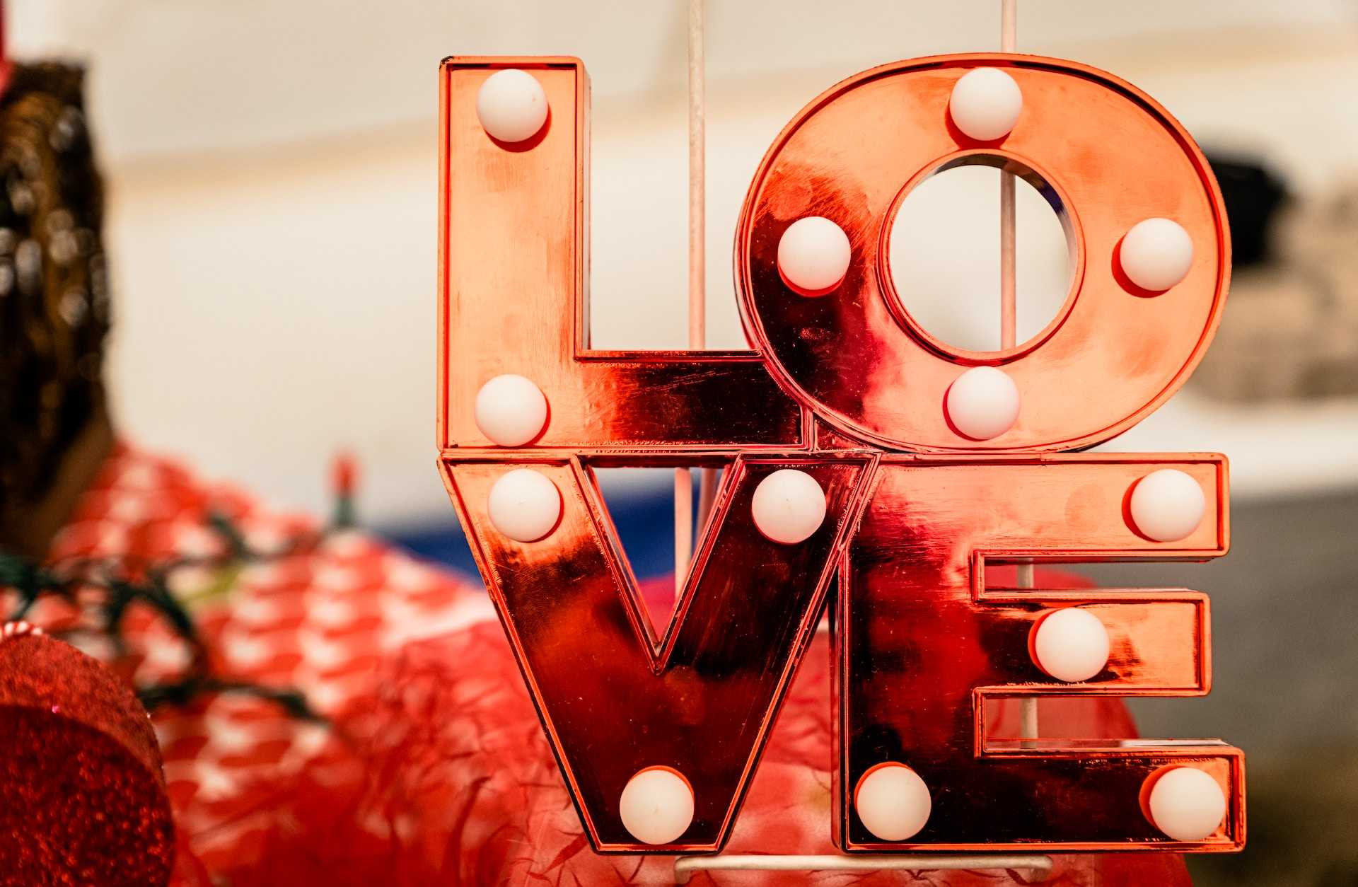 detail of a love-themed metal and light sign to send valentine's day quotes for him