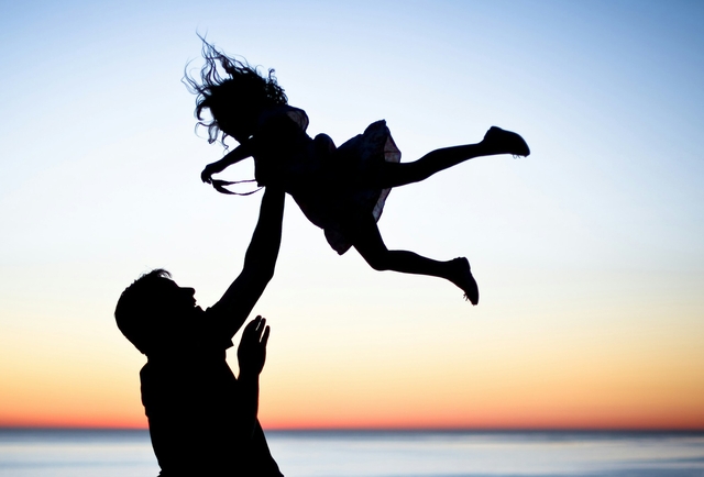father daughter quotes with father raising young daughter in the air on the beach at sunset
