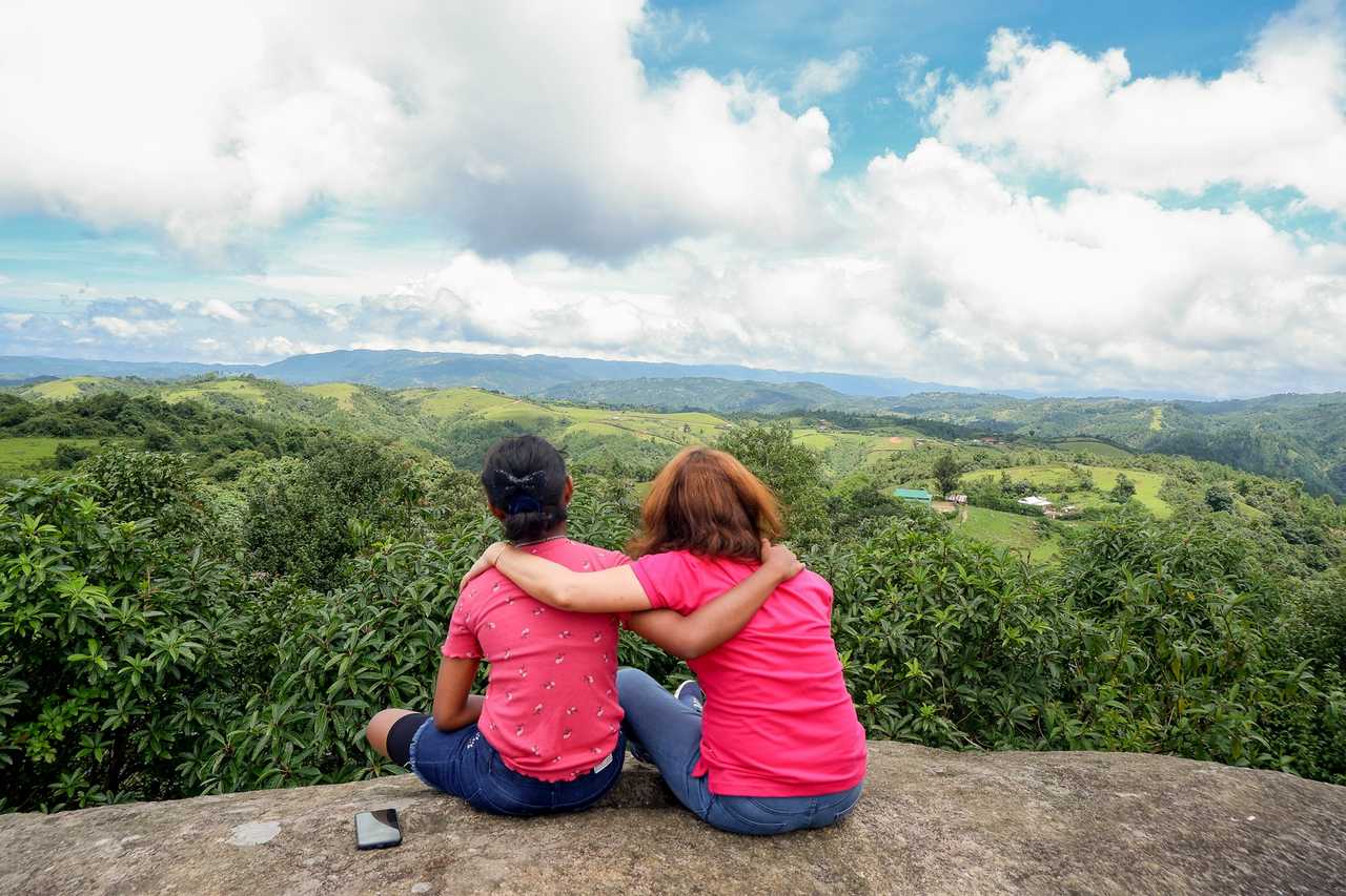 mother and daughter seating in a point of view looking at the hills below wearing pink shirts for daughter quotes
