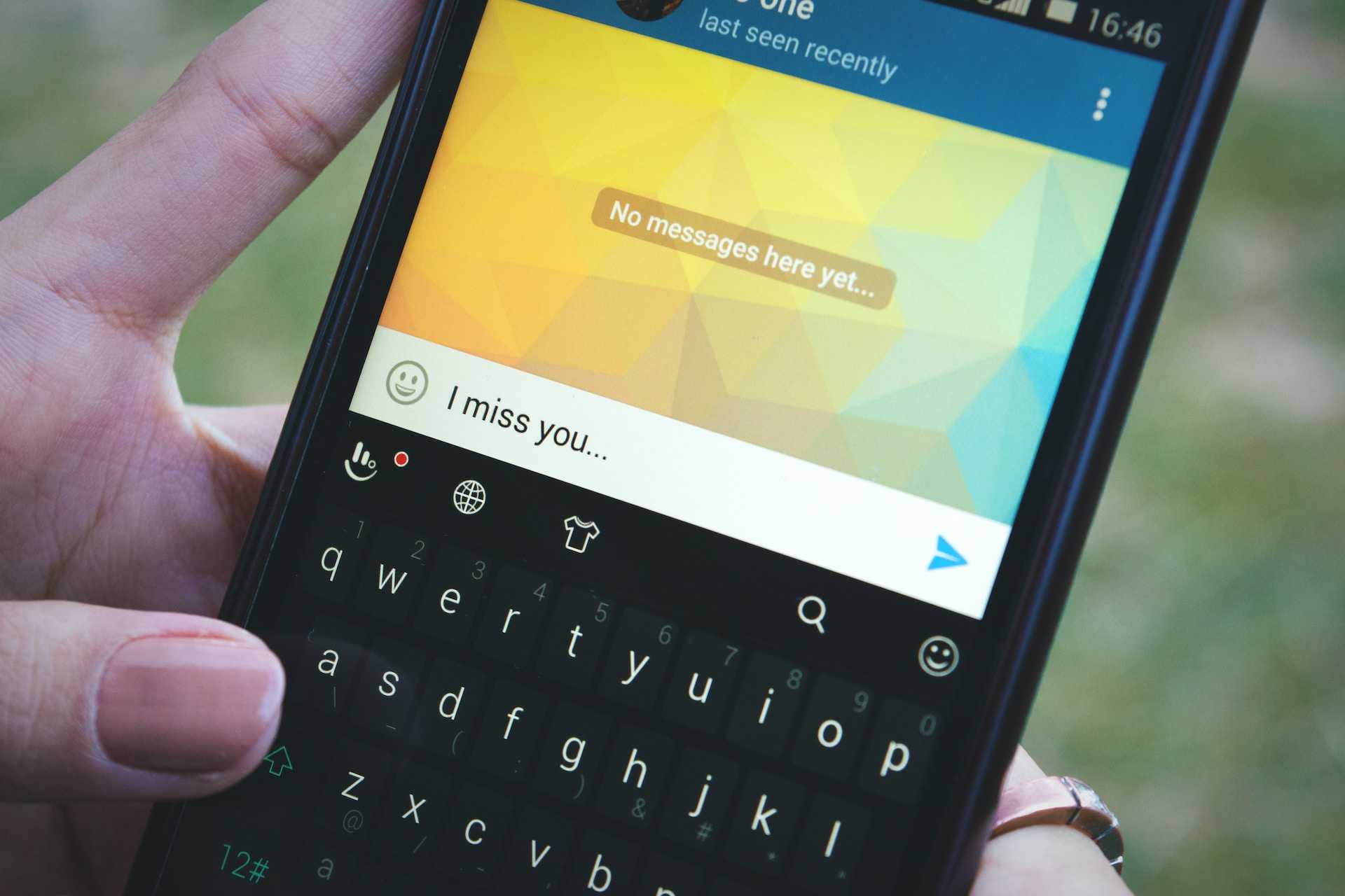 hand holding phone where we can read a miss you message typed by the user
