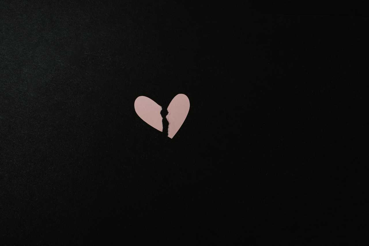 paper heart ripped in the middle over black background with break up messages for girlfriend