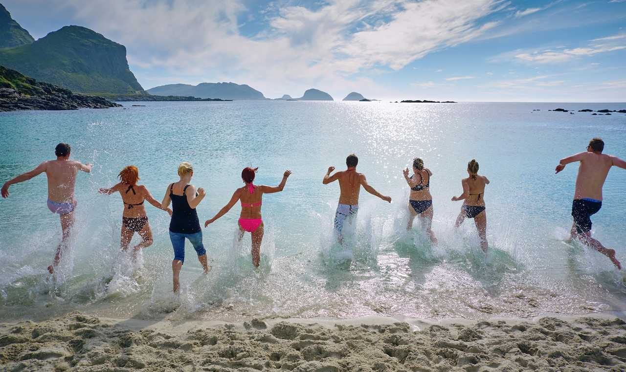 group of people going into the sea at the beach during a holiday for greeting cards