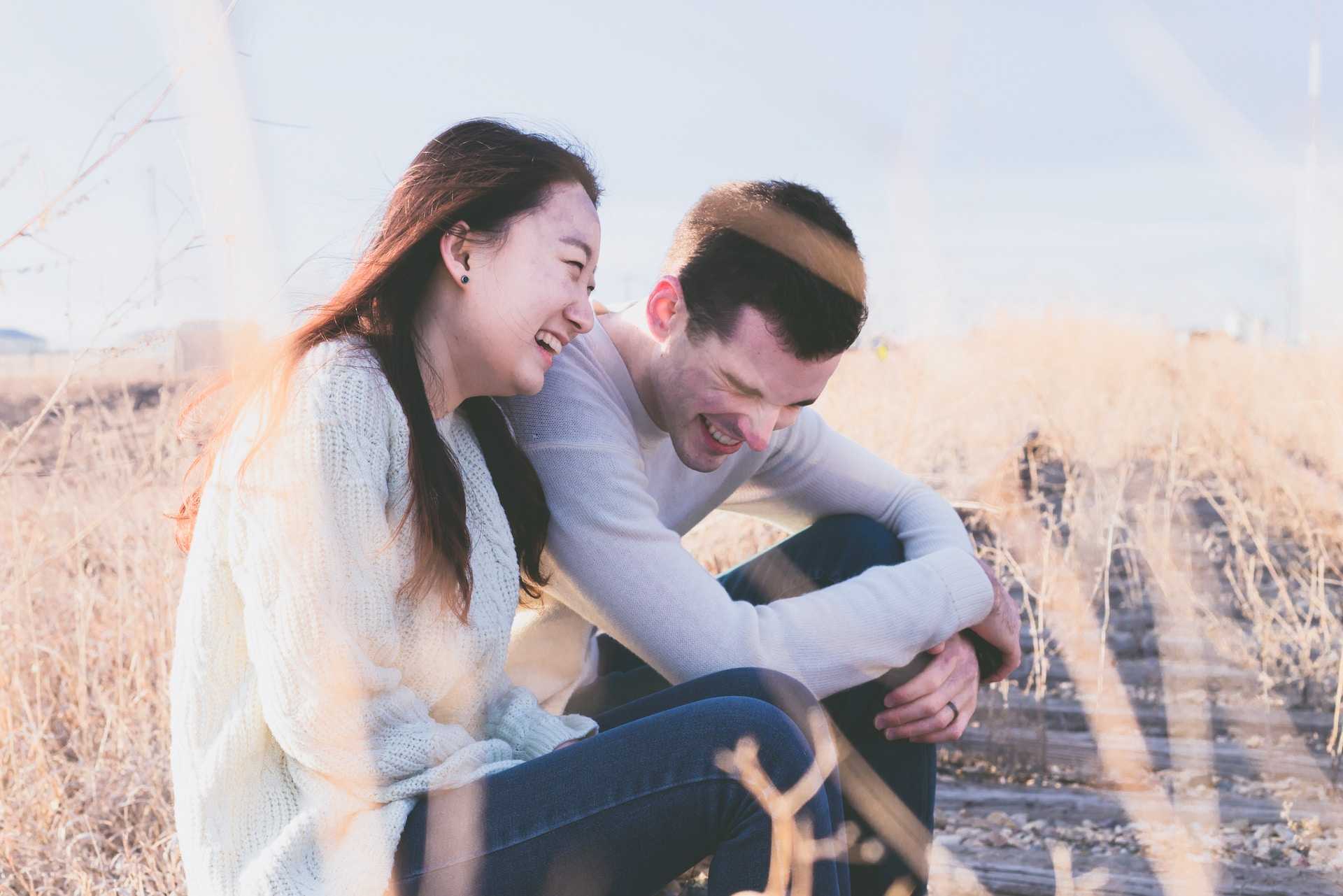 couple laughing in a field saying funny valentine's day quotes for him