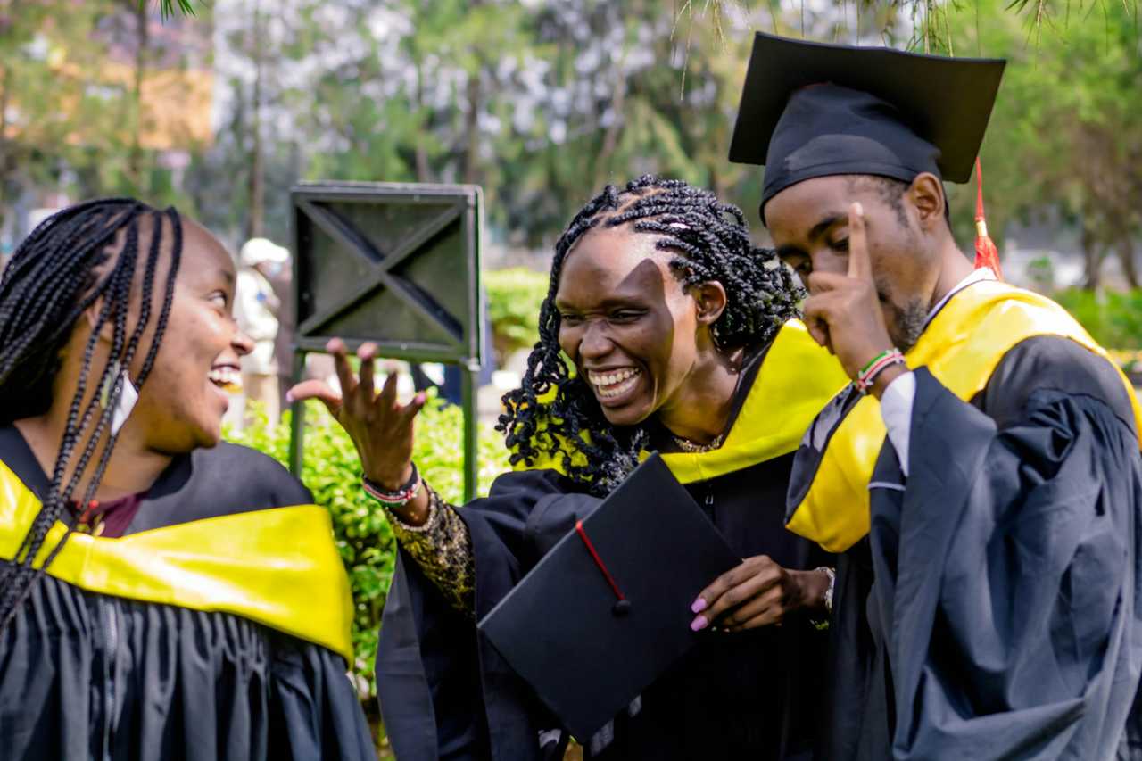 friends laughing and happy on graduation day wearing graduation clothes and saying messages of congratulations