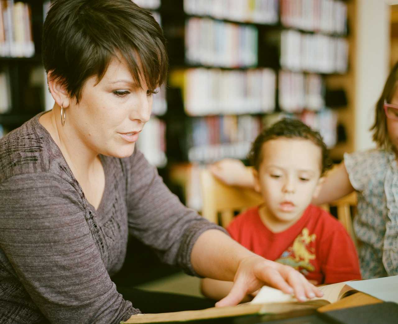 kindergarten teacher giving attention to a kid in kindergarten receiving thank you messages from parents