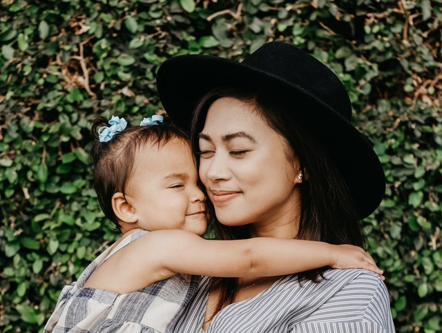 women wearing hat hugging child after happy mother's day wishes