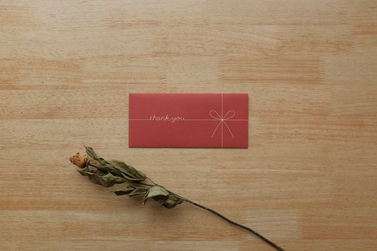 red thank you greeting card in a wooden table