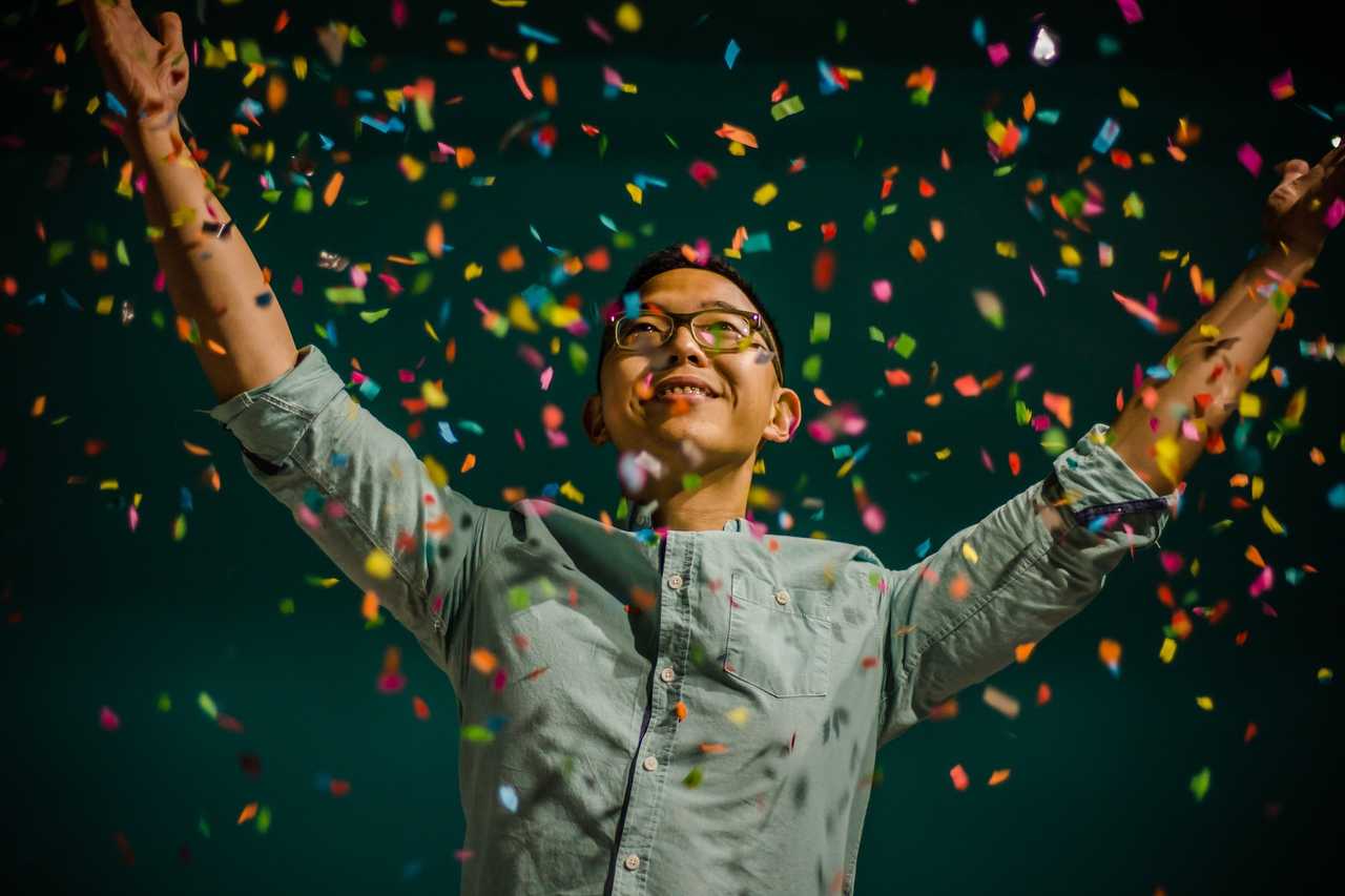 man with raised arms celebrating with confetti after ai generated congratulation messages